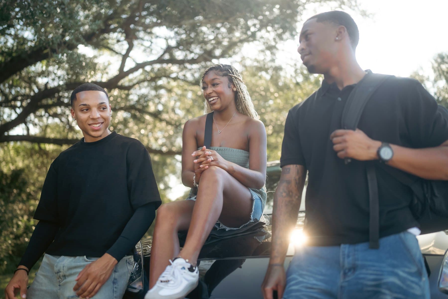 Three friends chatting and smiling outdoors in warm afternoon light